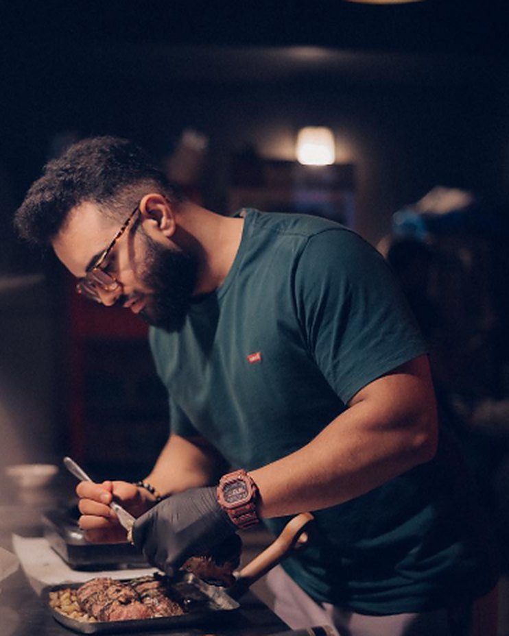 Chef Omer plating a steak in the Oysteaks kitchen
