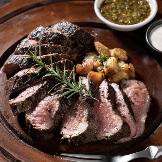 Sliced steak plated with chimichurri